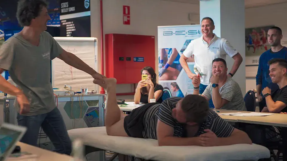 A B-E-St training day: a practitioner demonstrating a treatment on a course participant, the rest of the group watching